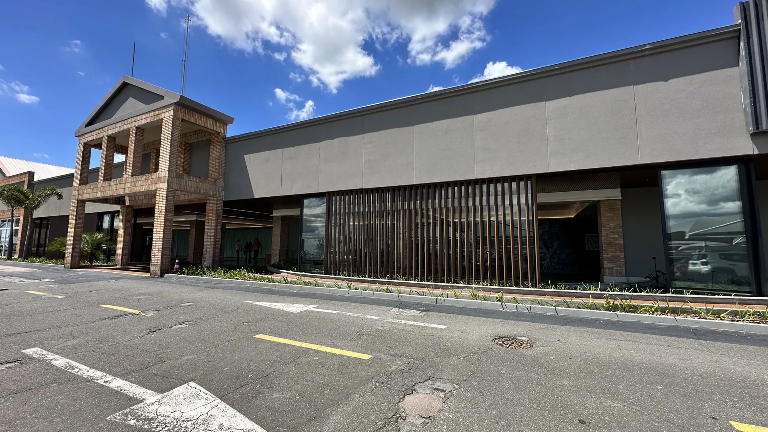 Fachada comercial com brises metálicos verticais em frente envidraçada