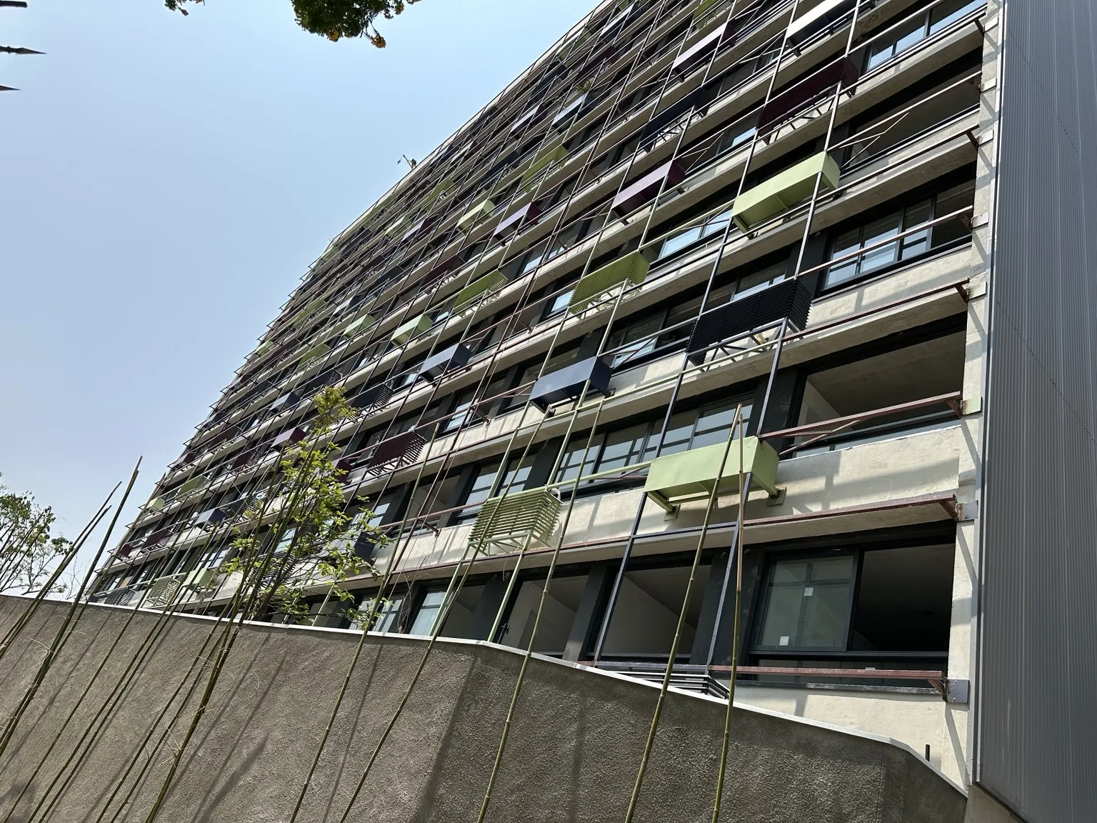 Fachada de edifício com guarda-corpos metálicos brancos repetidos nos pavimentos