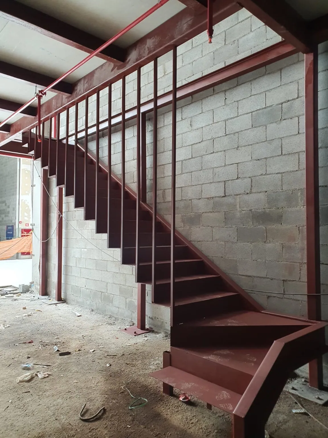 Escada metálica com guarda-corpos e degraus de aço em obra